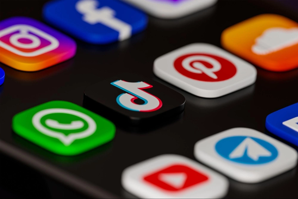 Close-up of smartphone screen showing popular social media app icons including TikTok, Instagram, Facebook, Pinterest, and WhatsApp.