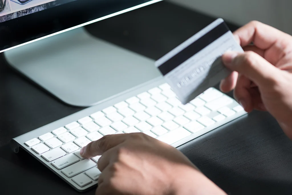 A close up photo of a consumer with their credit card making an online purchase from brand 