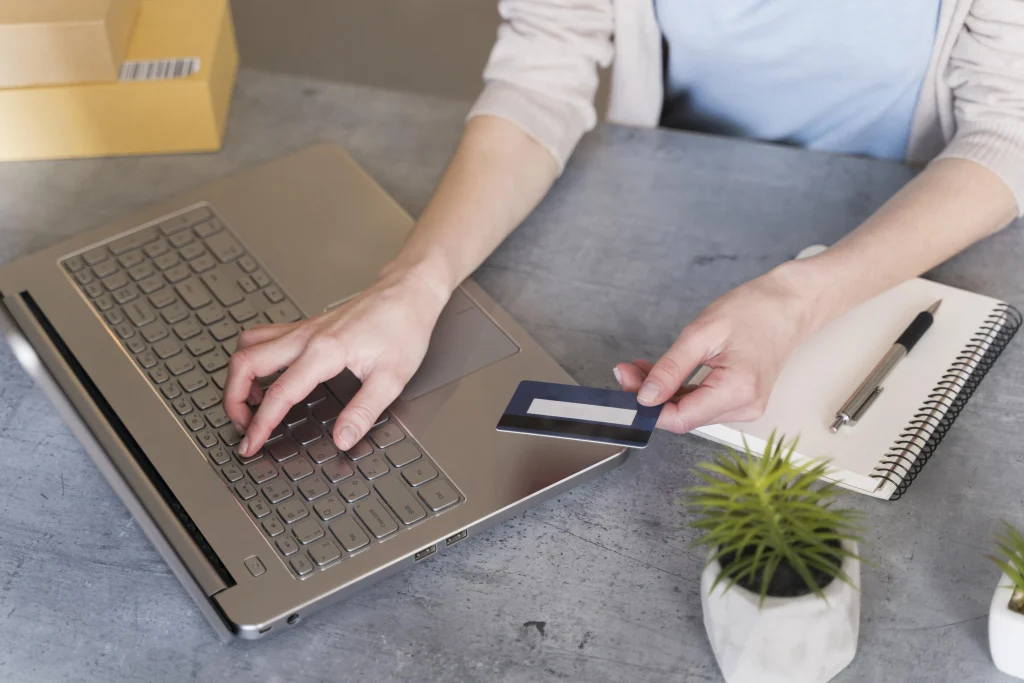Image of woman using her laptop to make an online prucahse with her credit card