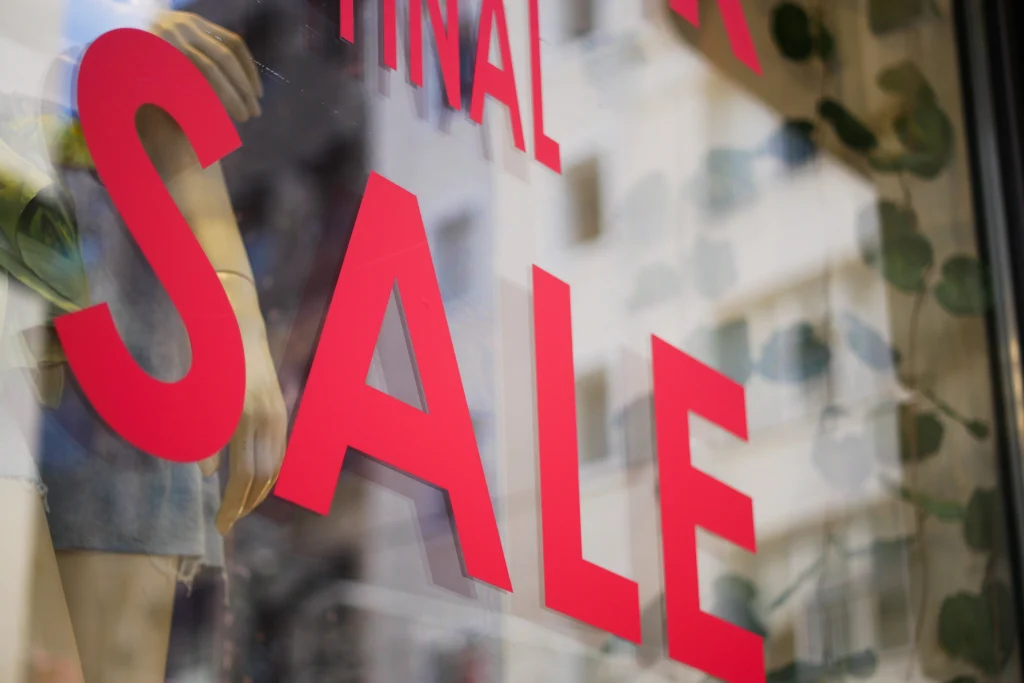 A front store glass window with red letters spelling the words "final sale"